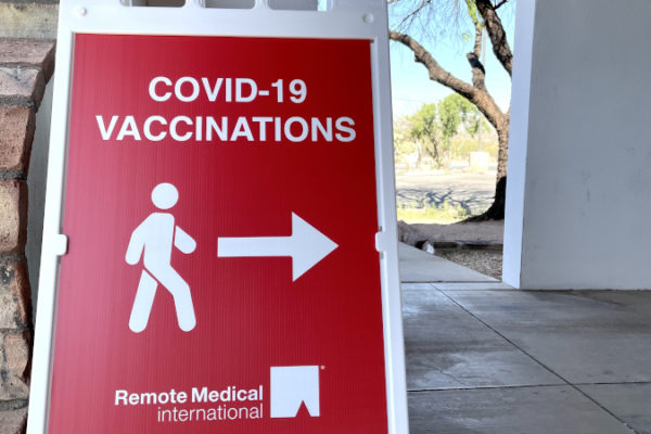 An RMI COVID Vaccinations sign with an arrow pointing.